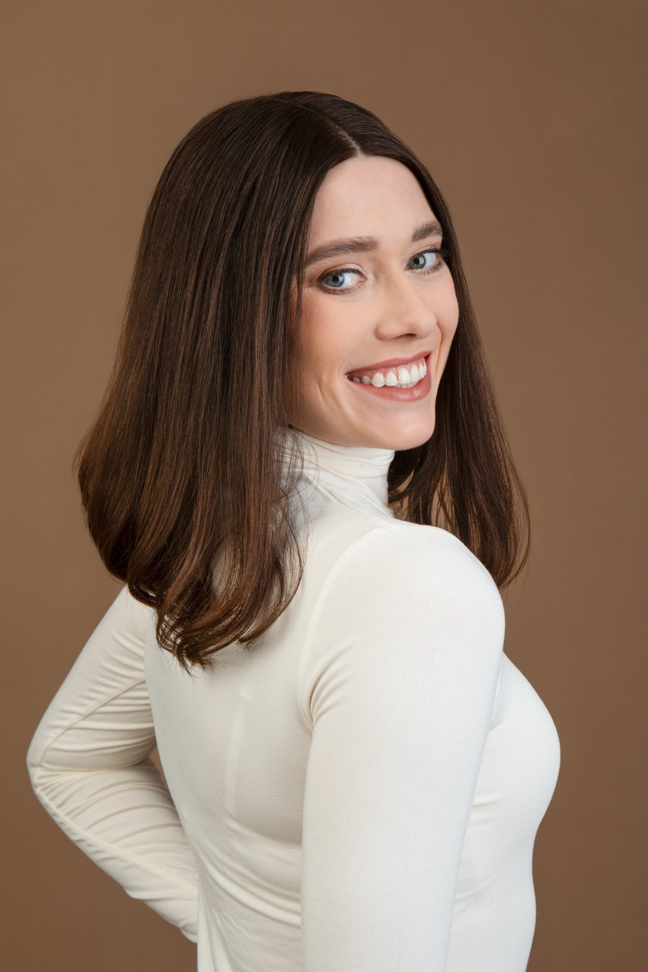Model turning to show the soft flipped finish of her GOLDWIGS brunette human hair wig